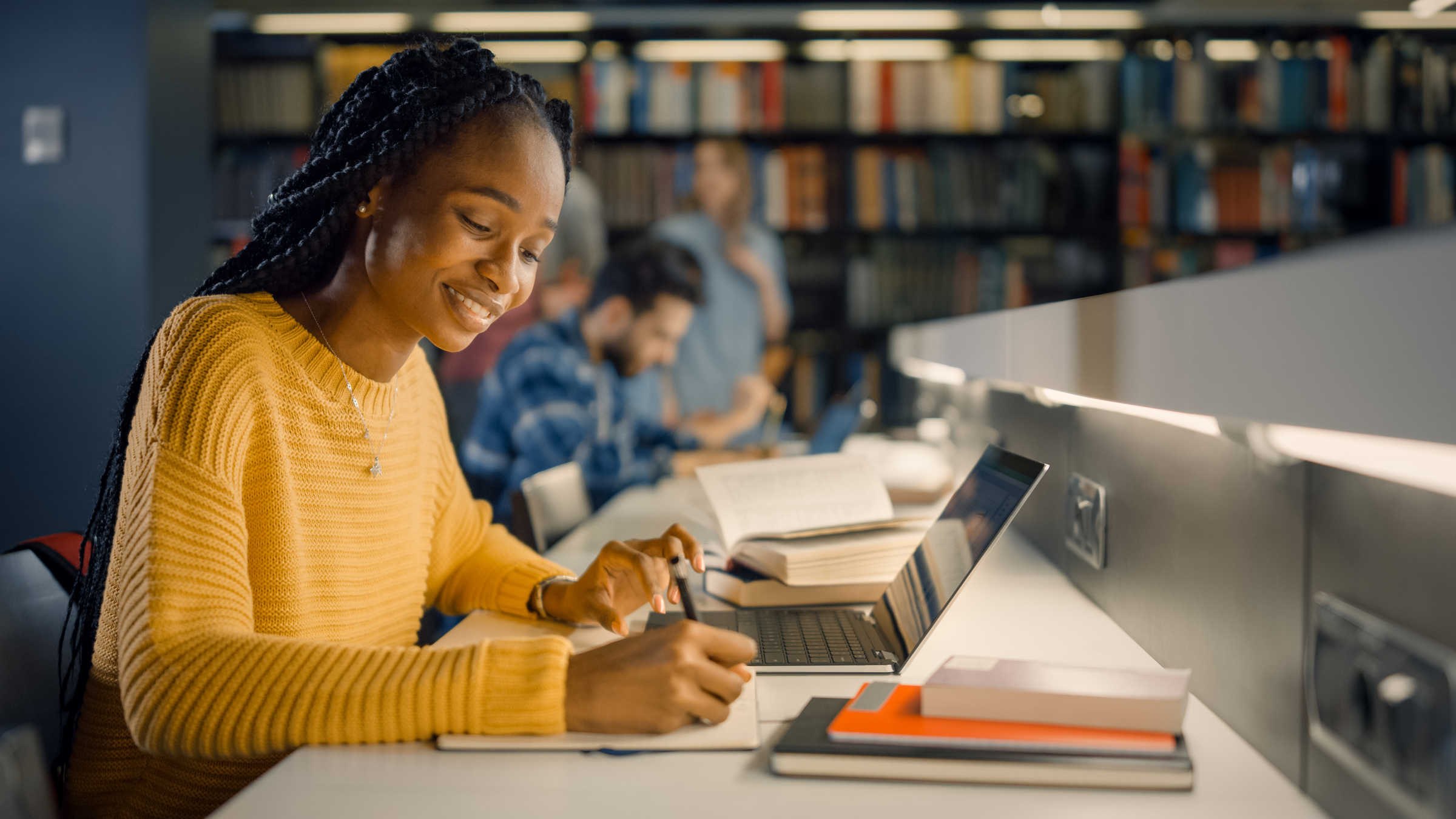 Young woman studying on laptop in library